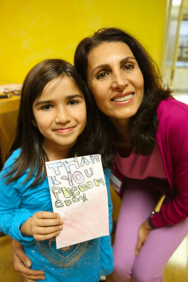 Fariba smiles with a young student.