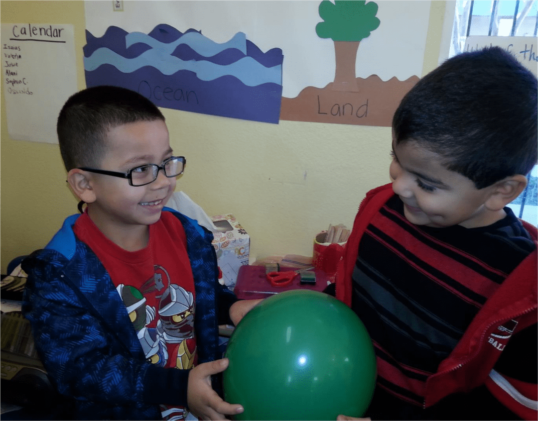 Two children play with a ball.