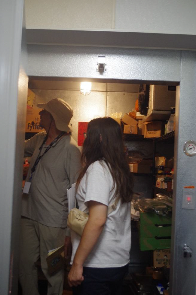 Joe Halay, a Hospitality House facilities manager, explained the inner workings of the building's energy systems, as Logan checked the gauges. (Photo by Amelia Regan)