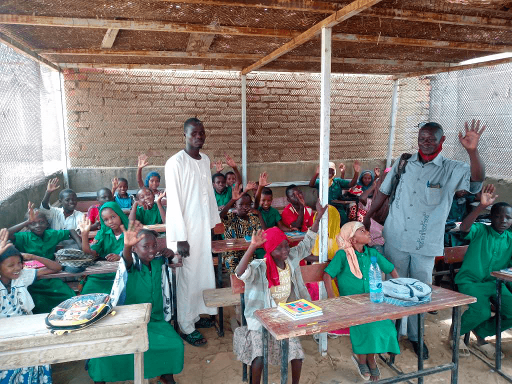 A class of students in a room with their two teachers.