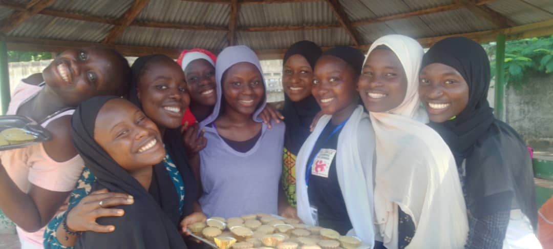 Students gathered around a plate, smiling 