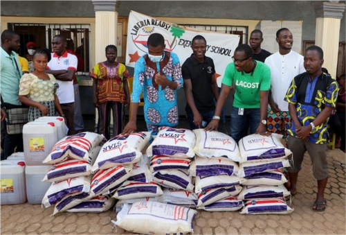 A group stands behind piles of dry food.