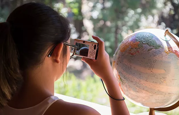 A student takes of a globe on a stand with