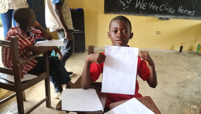 A student holds up his paper to show