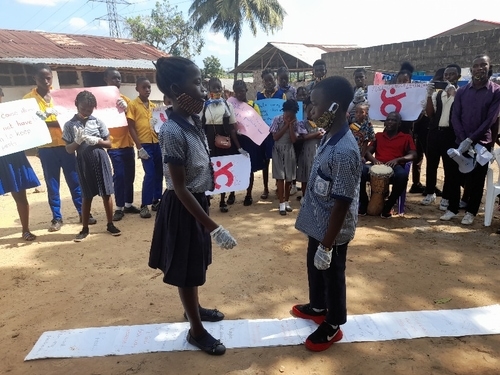 Students face each other on a project mat.