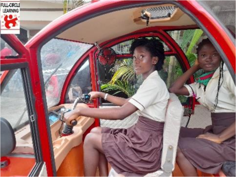 Two students in a vehicle looking out.