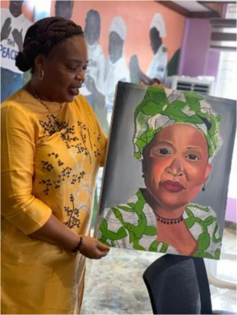 A woman presents a painting while talking.