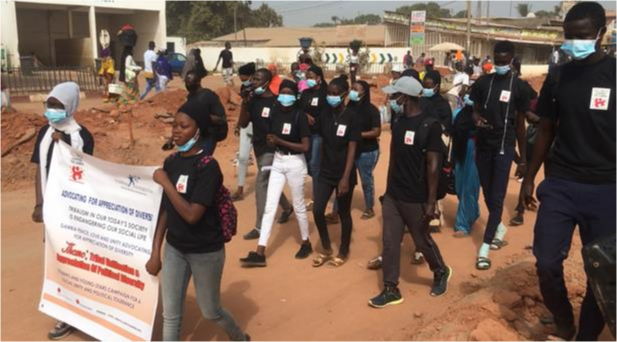 A group of students walk together carrying a banner.